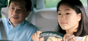 image of father teaching his daughter how to drive 